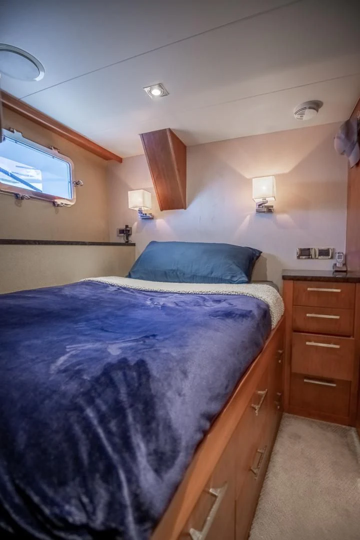 a bed with a blue comforter aboard FUGITIVE *NAME RESERVED* Yacht for Sale