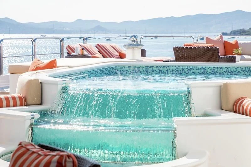 a pool with a view of the mountains in the background aboard LUCKY LADY Yacht for Sale