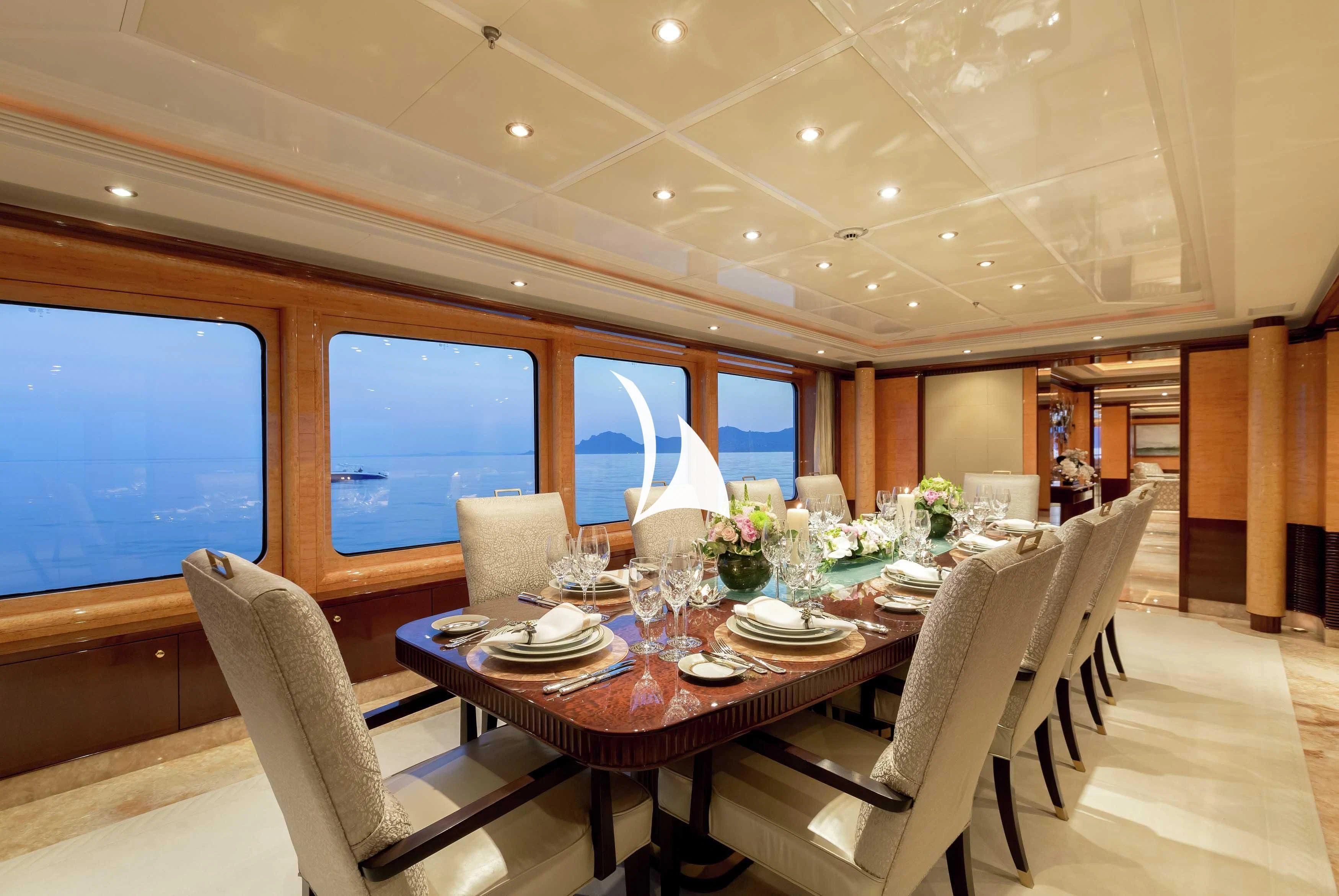 a dining table with chairs and a large window aboard LUCKY LADY Yacht for Sale