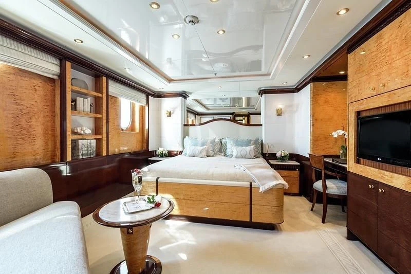 a large bedroom with a bed and a coffee table aboard LUCKY LADY Yacht for Sale