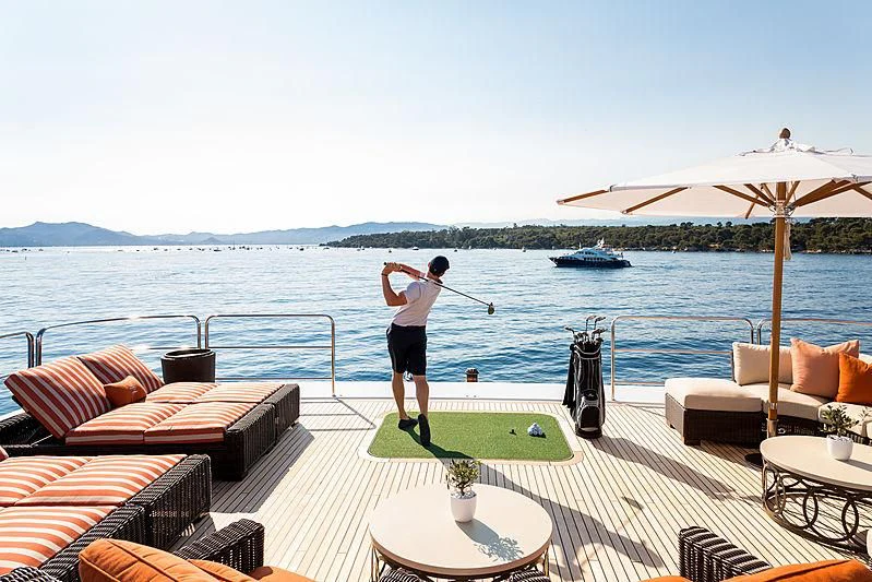 a person playing golf on a deck aboard LUCKY LADY Yacht for Sale