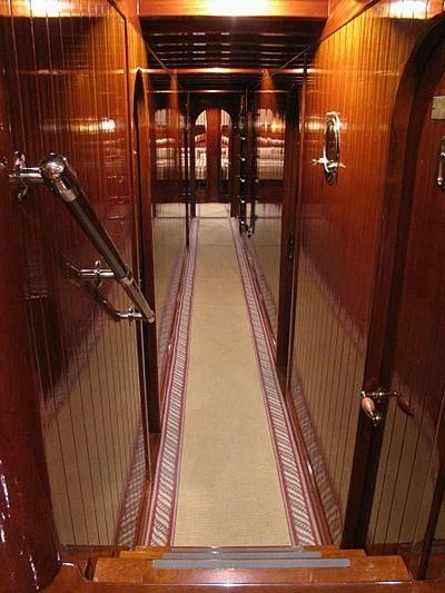a long hallway with glass doors aboard AGANIPPE Yacht for Sale