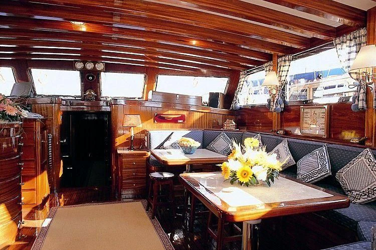 a room with a table and chairs aboard AGANIPPE Yacht for Sale