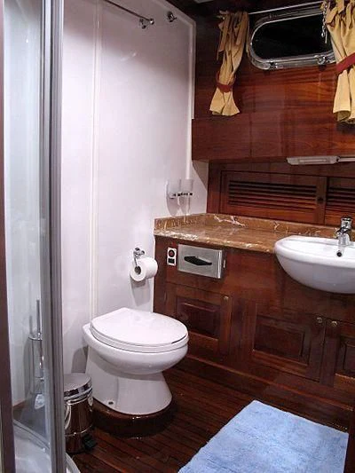 a bathroom with a sink toilet and a mirror aboard AGANIPPE Yacht for Sale