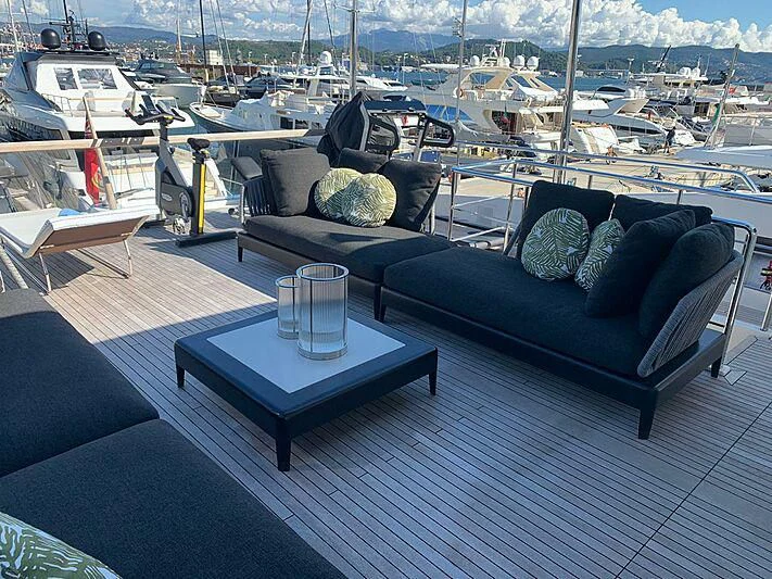 a couch and a table on a deck overlooking a marina aboard EMY Yacht for Sale