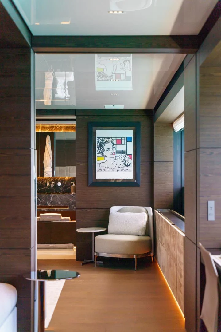 a room with a chair and a painting on the wall aboard ASANTE Yacht for Sale