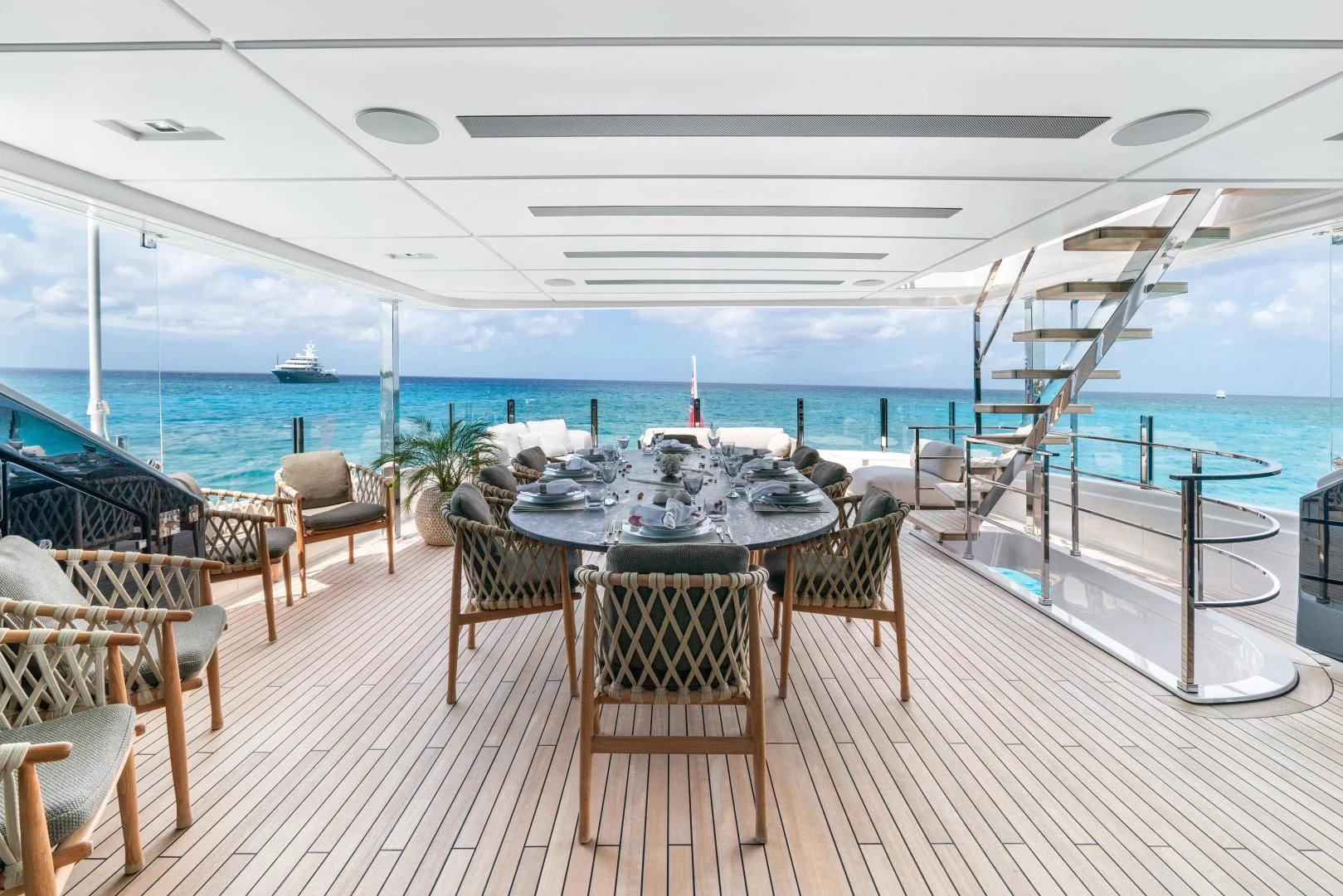 a table and chairs on a deck overlooking a body of water aboard ASANTE Yacht for Sale