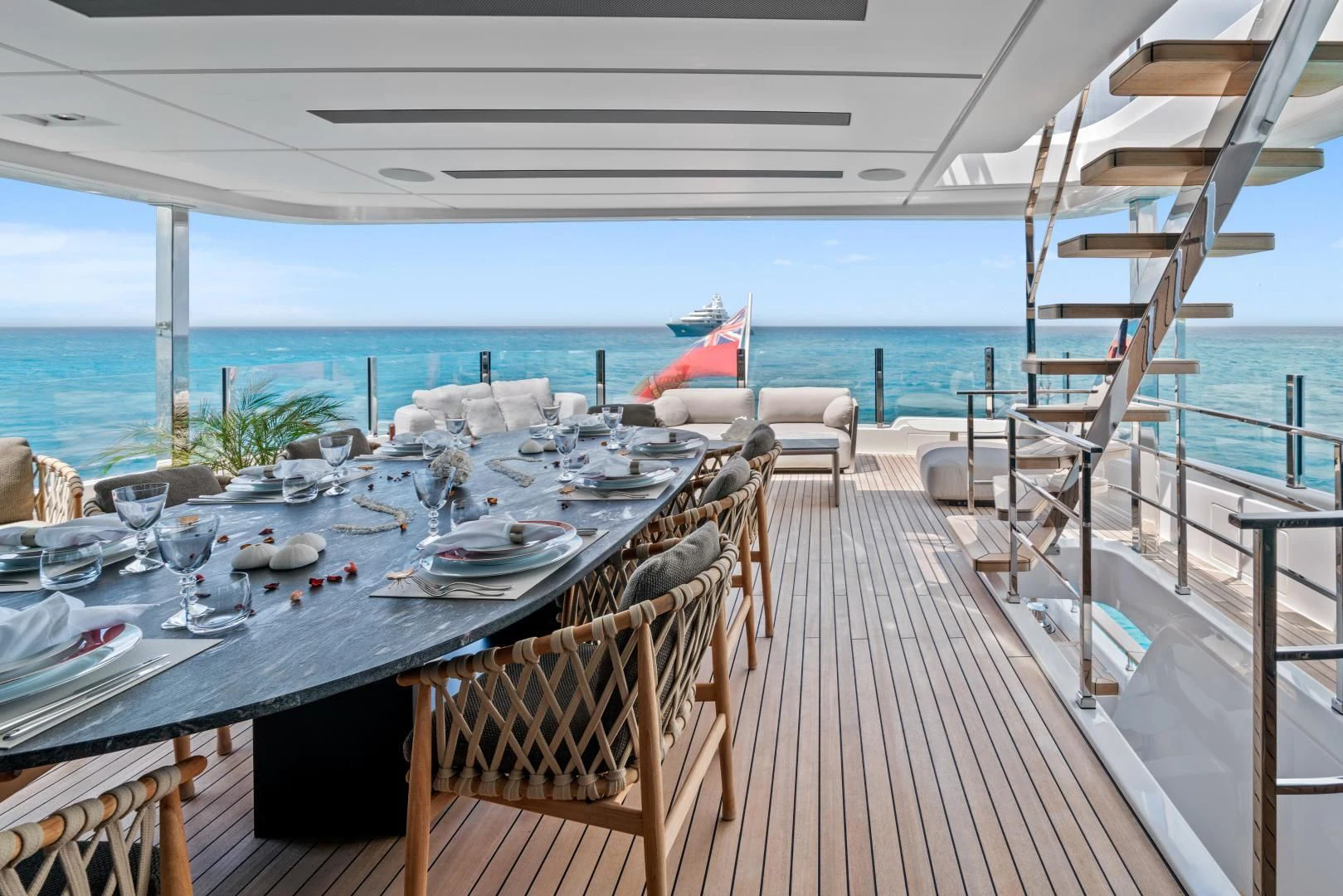 a table set for a meal on a deck overlooking the ocean aboard ASANTE Yacht for Sale