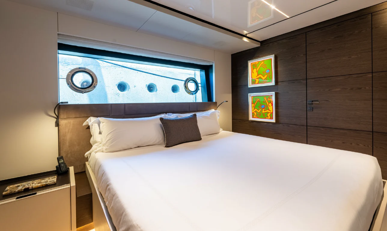 a bed with a white sheet and a blue headboard aboard ASANTE Yacht for Sale