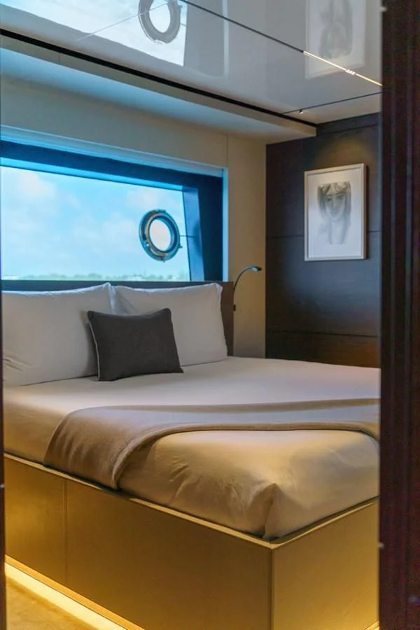 a bed with a painting on the wall aboard ASANTE Yacht for Sale