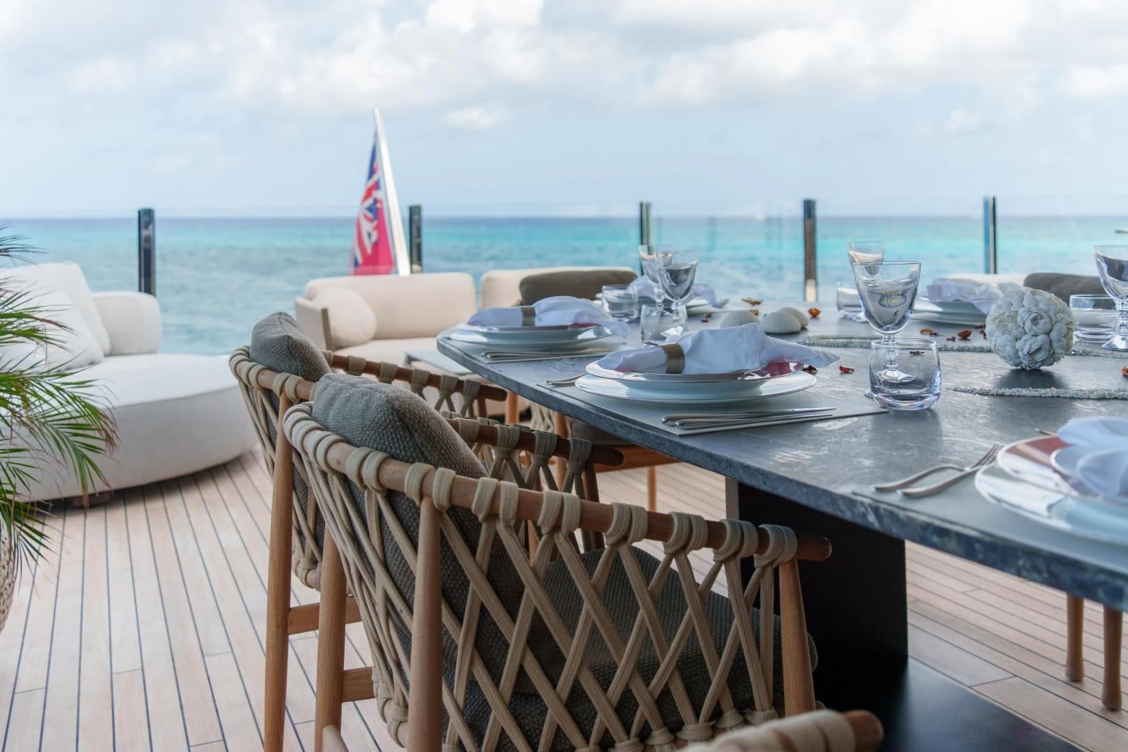 a table with plates and glasses on it by a beach aboard ASANTE Yacht for Sale
