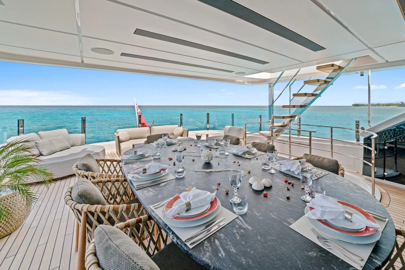 a table set for a meal on a balcony overlooking the ocean aboard ASANTE Yacht for Sale