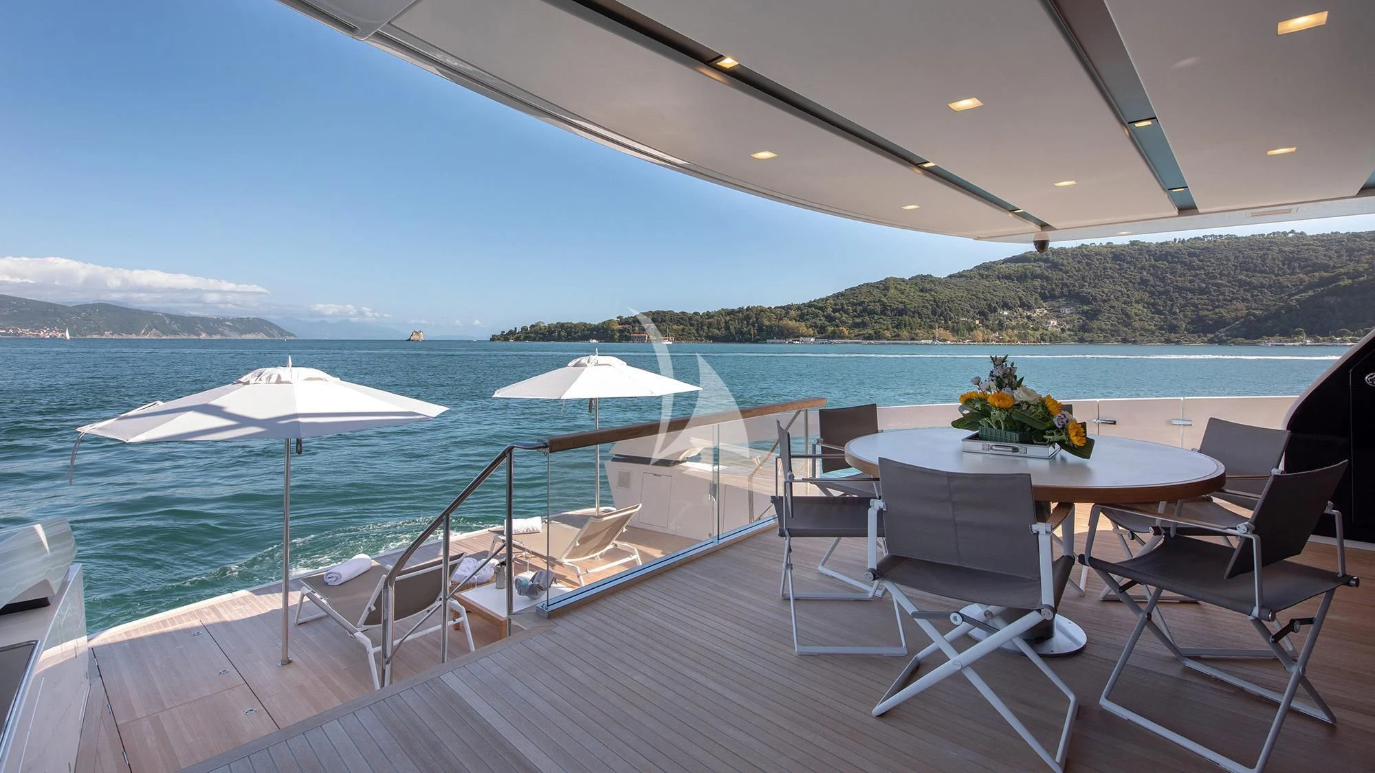 a patio with tables and chairs and umbrellas on it aboard TIBERIAS Yacht for Sale