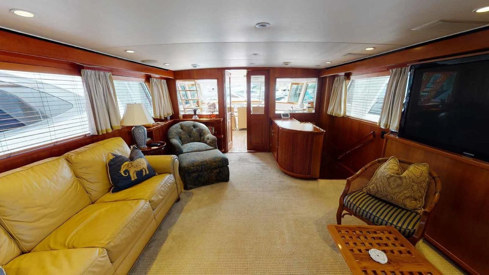 a living room with a yellow couch and a television aboard LORELEI Yacht for Sale
