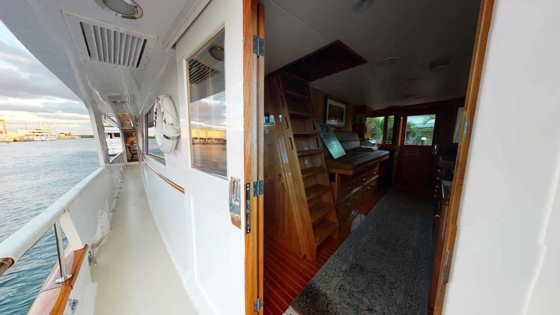 a room with a balcony and a table and a clock on the wall aboard LORELEI Yacht for Sale