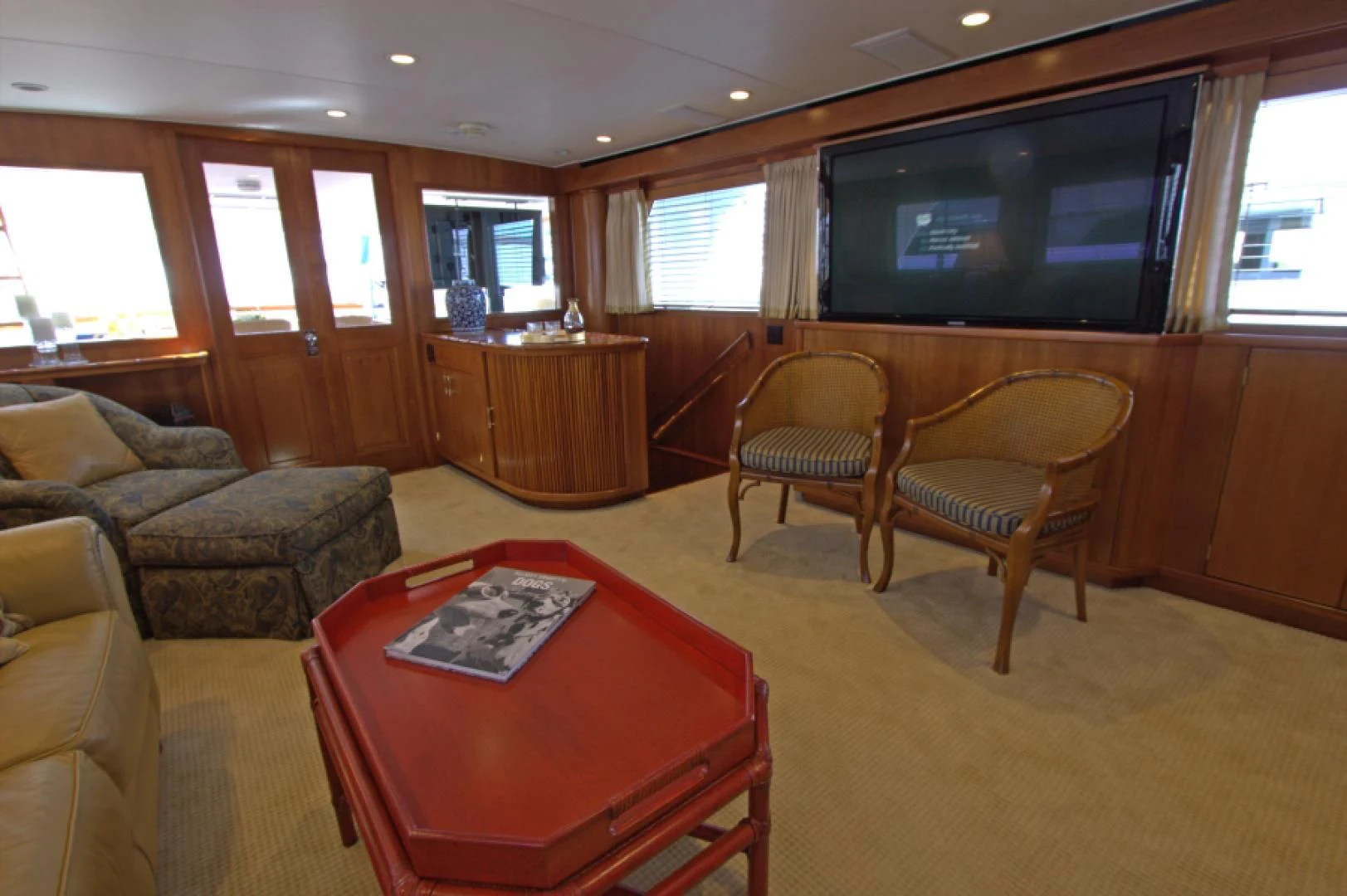 a living room with a tv and a table aboard LORELEI Yacht for Sale