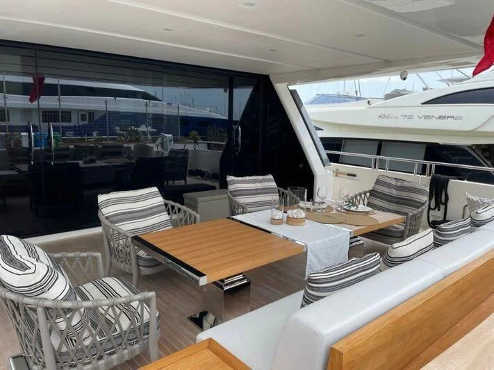 a room with tables chairs and a large window aboard PIACERE III Yacht for Sale