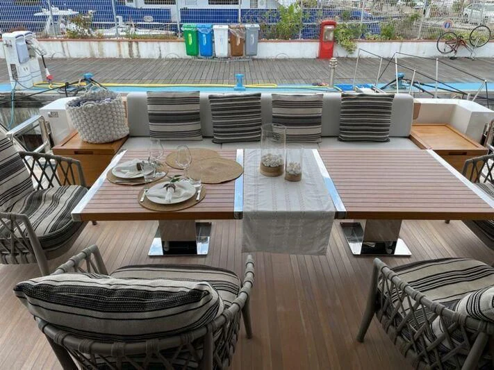 a table with chairs and a pool aboard PIACERE III Yacht for Sale
