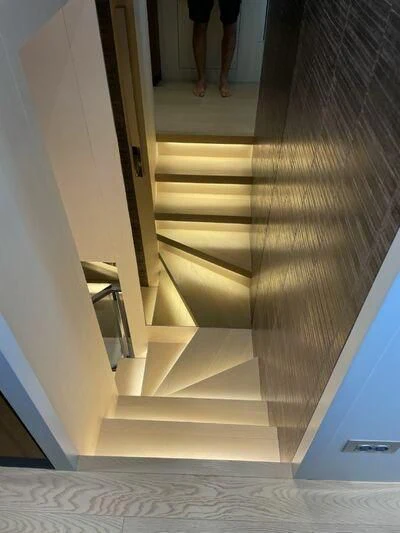 a person walking up a flight of stairs aboard PIACERE III Yacht for Sale