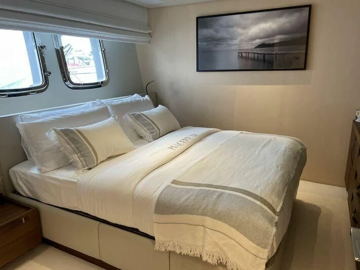 a bed with a white comforter aboard PIACERE III Yacht for Sale