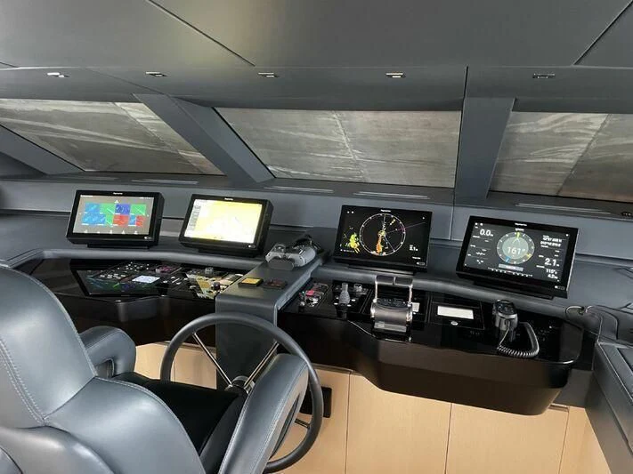 a room with many monitors and keyboards aboard PIACERE III Yacht for Sale