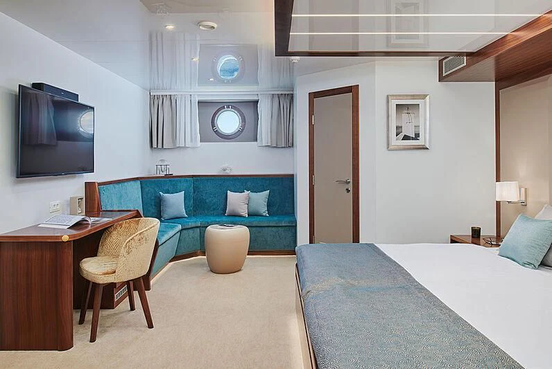 a bedroom with a bed and a television aboard CORSARIO Yacht for Charter