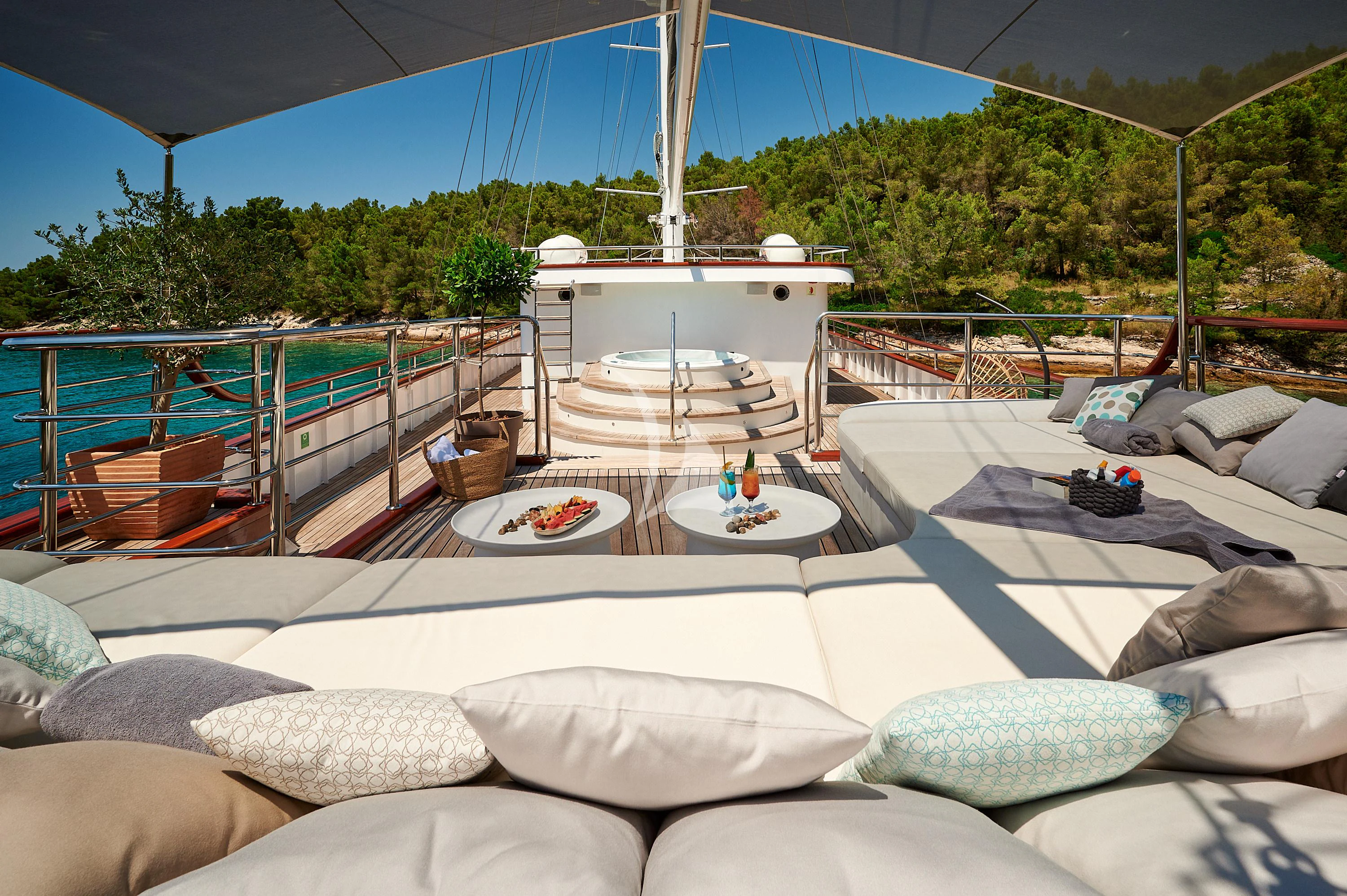 a large white bed with a table on it aboard CORSARIO Yacht for Charter