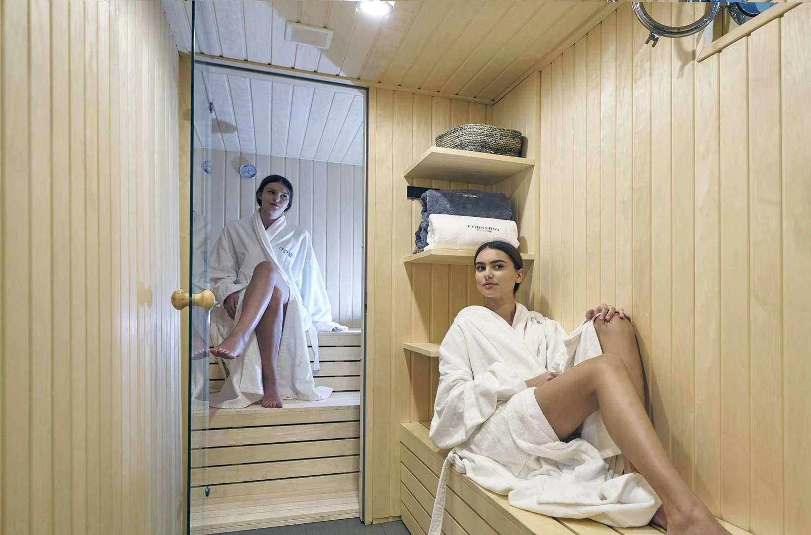 a person in a white robe sitting in a chair in a room aboard CORSARIO Yacht for Charter