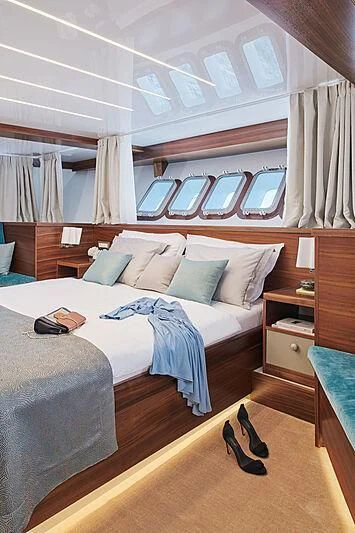 a bedroom with a bed and a window aboard CORSARIO Yacht for Charter