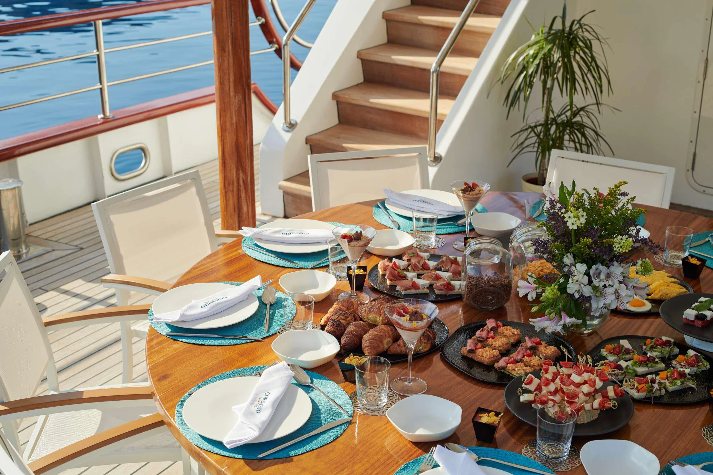 a table with plates and glasses on it aboard CORSARIO Yacht for Charter