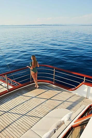 a person standing on a deck of a boat aboard CORSARIO Yacht for Charter