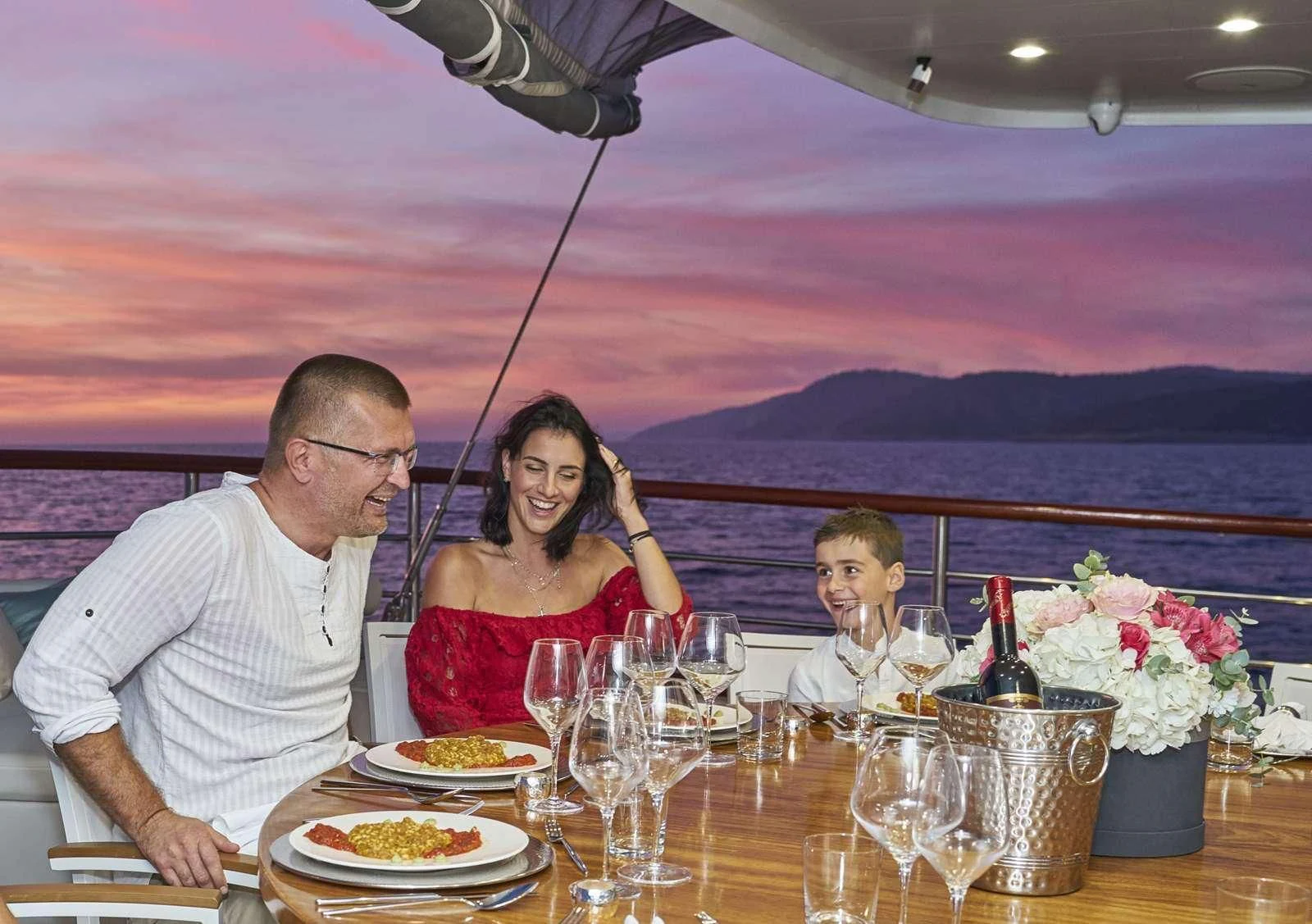 a group of people sitting at a table with food and drinks aboard CORSARIO Yacht for Charter