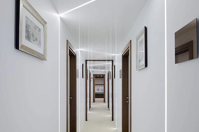 a hallway with a door and pictures on the wall aboard CORSARIO Yacht for Charter