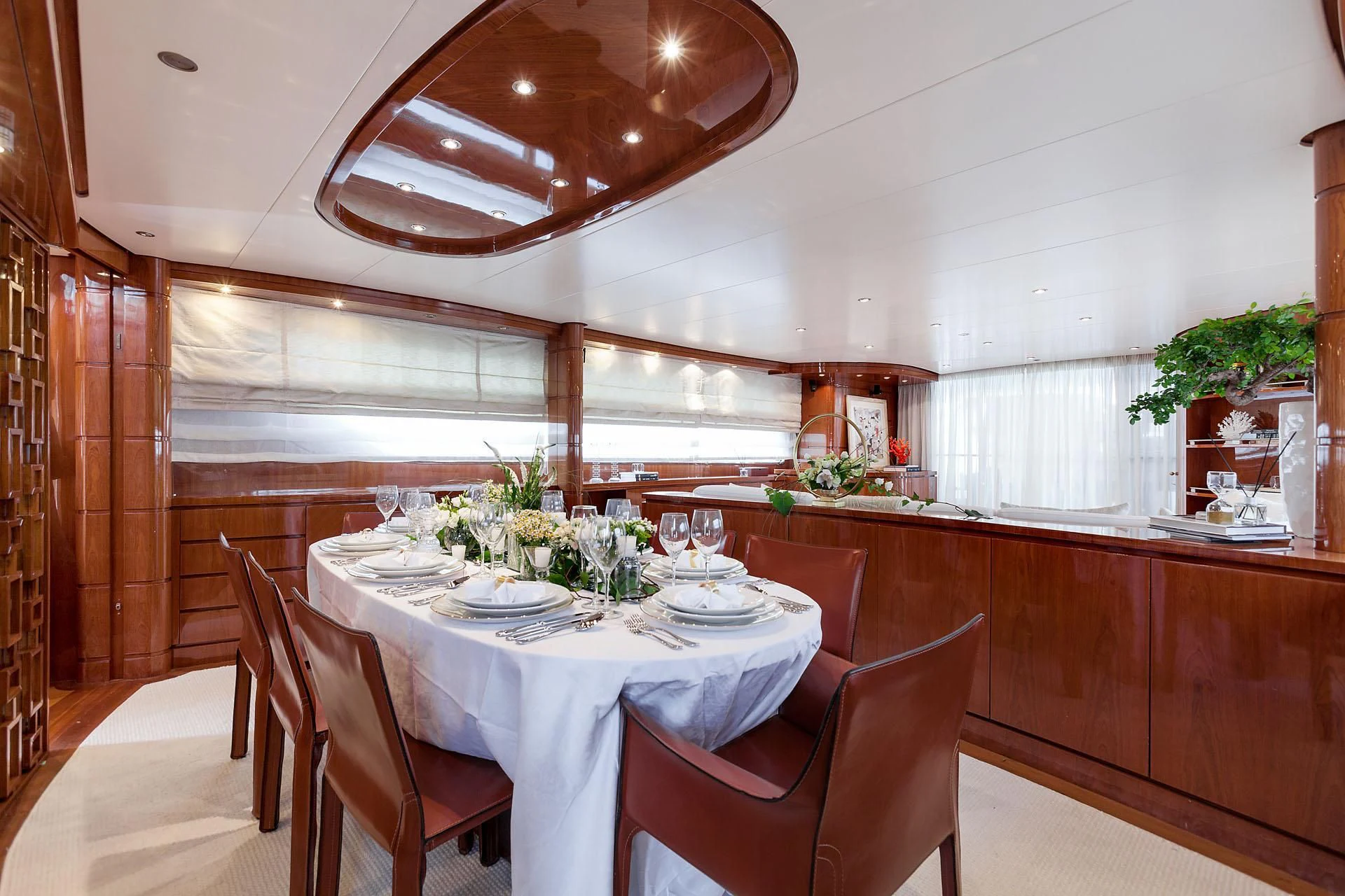 a dining table and chairs in a room with wood walls aboard ZEN Yacht for Sale