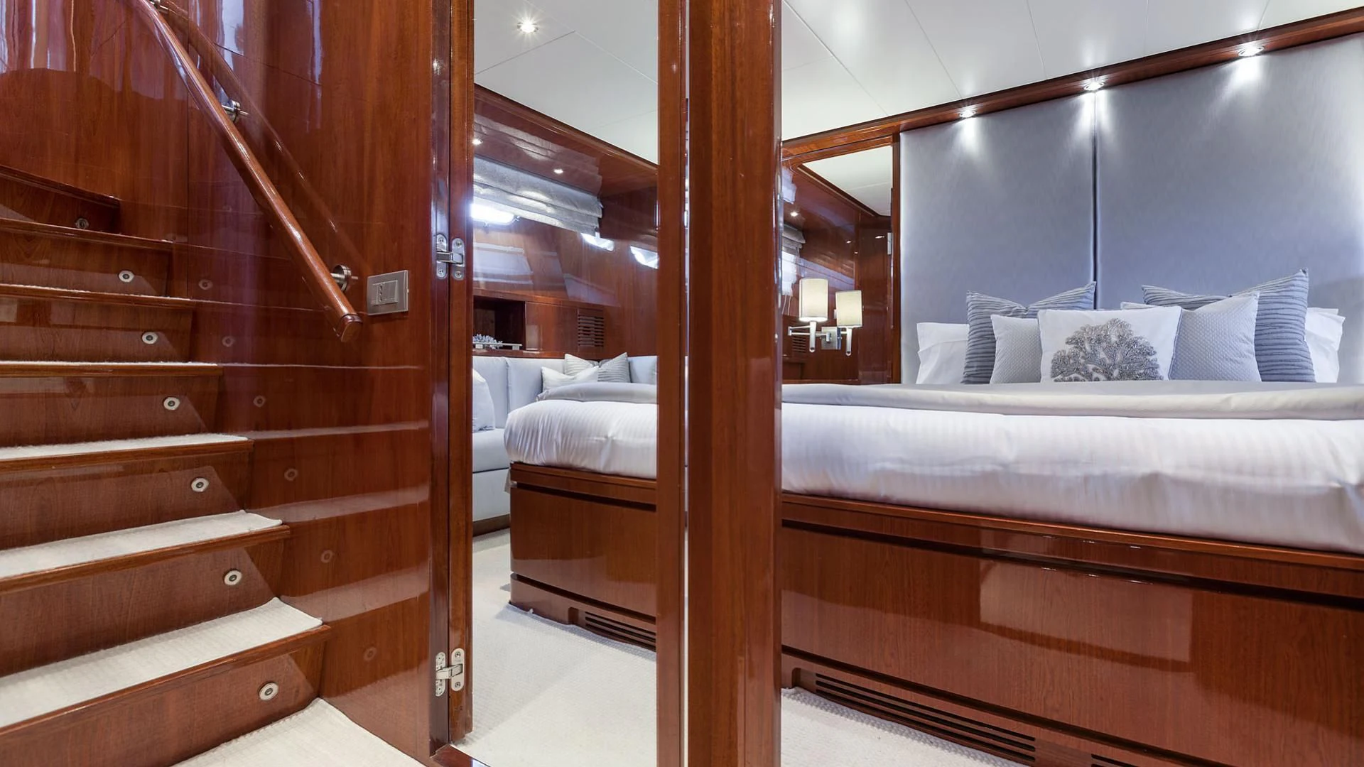 a room with a bed and a wood stair case aboard ZEN Yacht for Sale