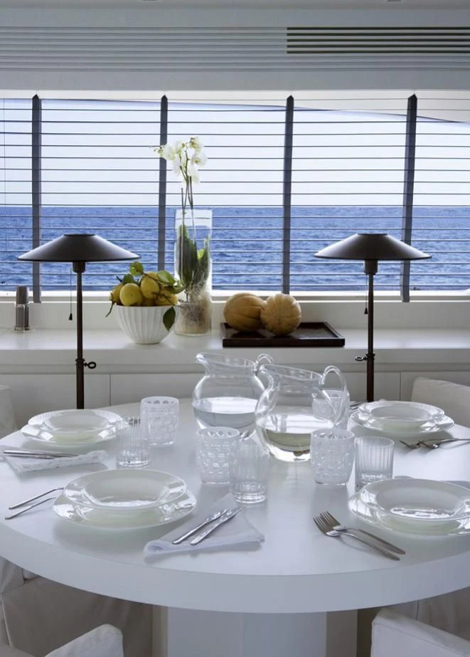 a table with plates and glasses aboard NIKCA Yacht for Sale