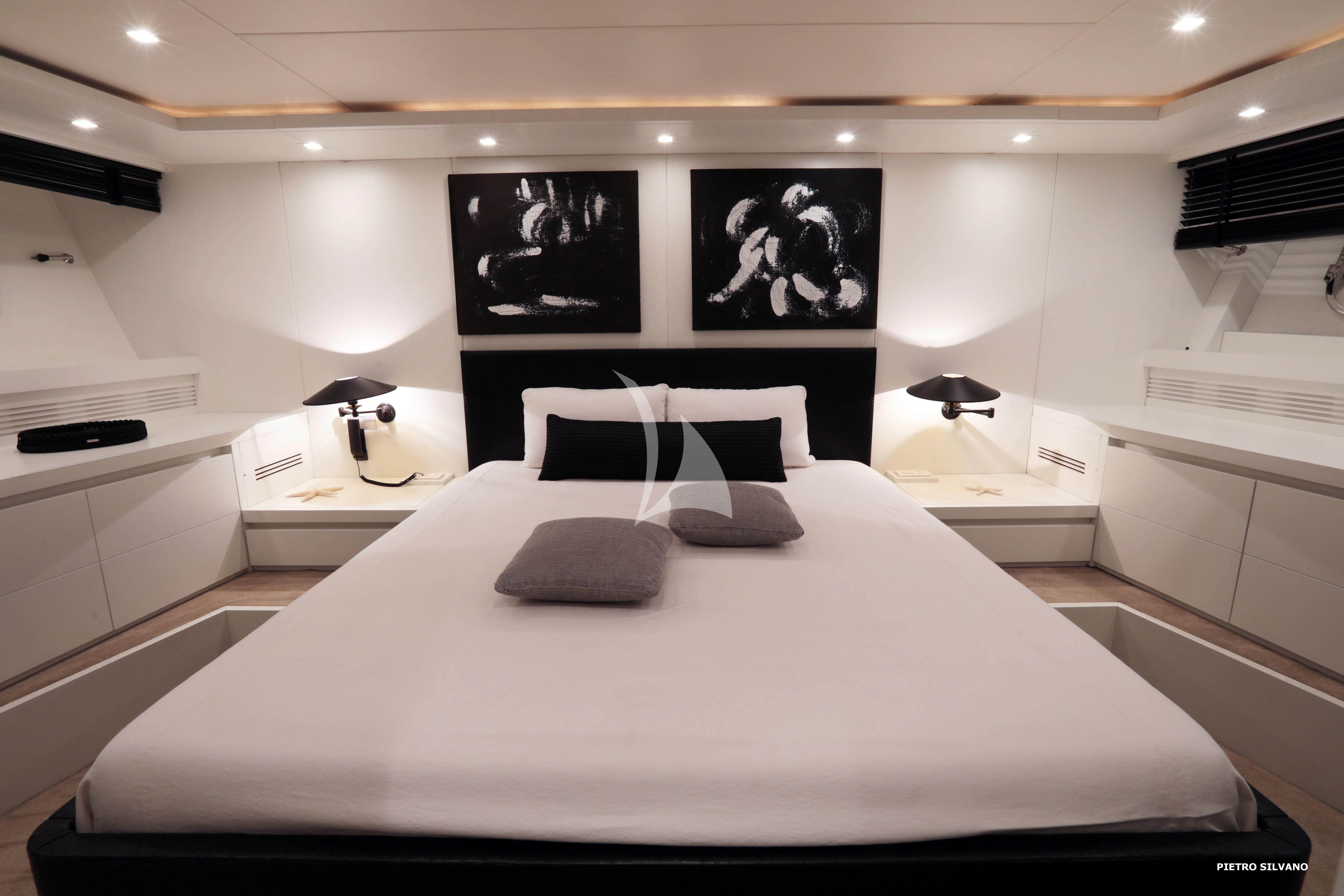 a large white bed with black pillows aboard NIKCA Yacht for Sale