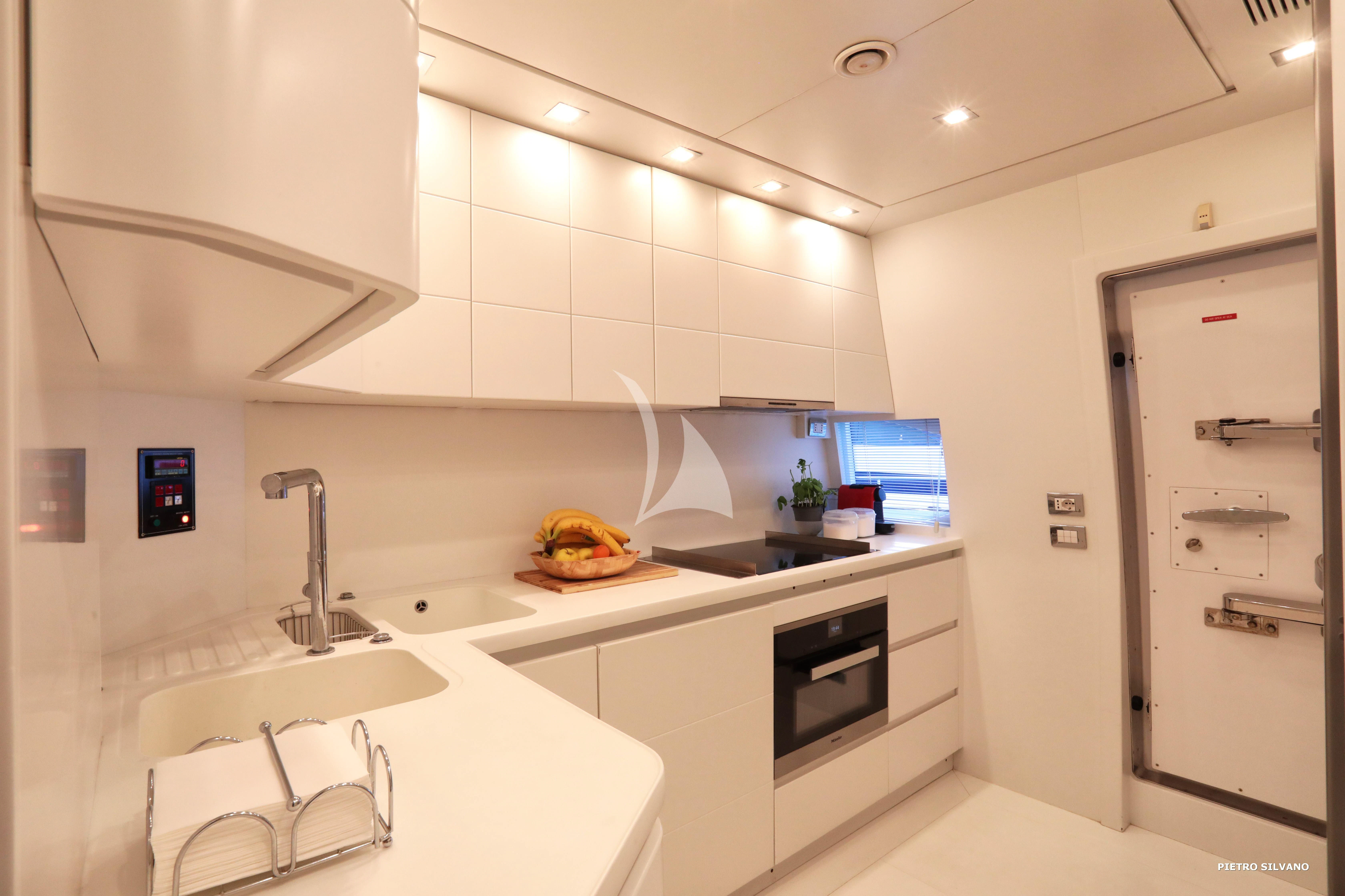 a kitchen with white cabinets aboard NIKCA Yacht for Sale