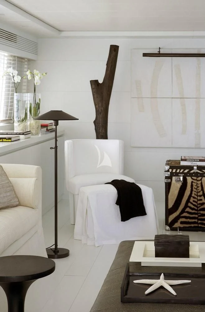 a living room with a white couch and a black chair aboard NIKCA Yacht for Sale