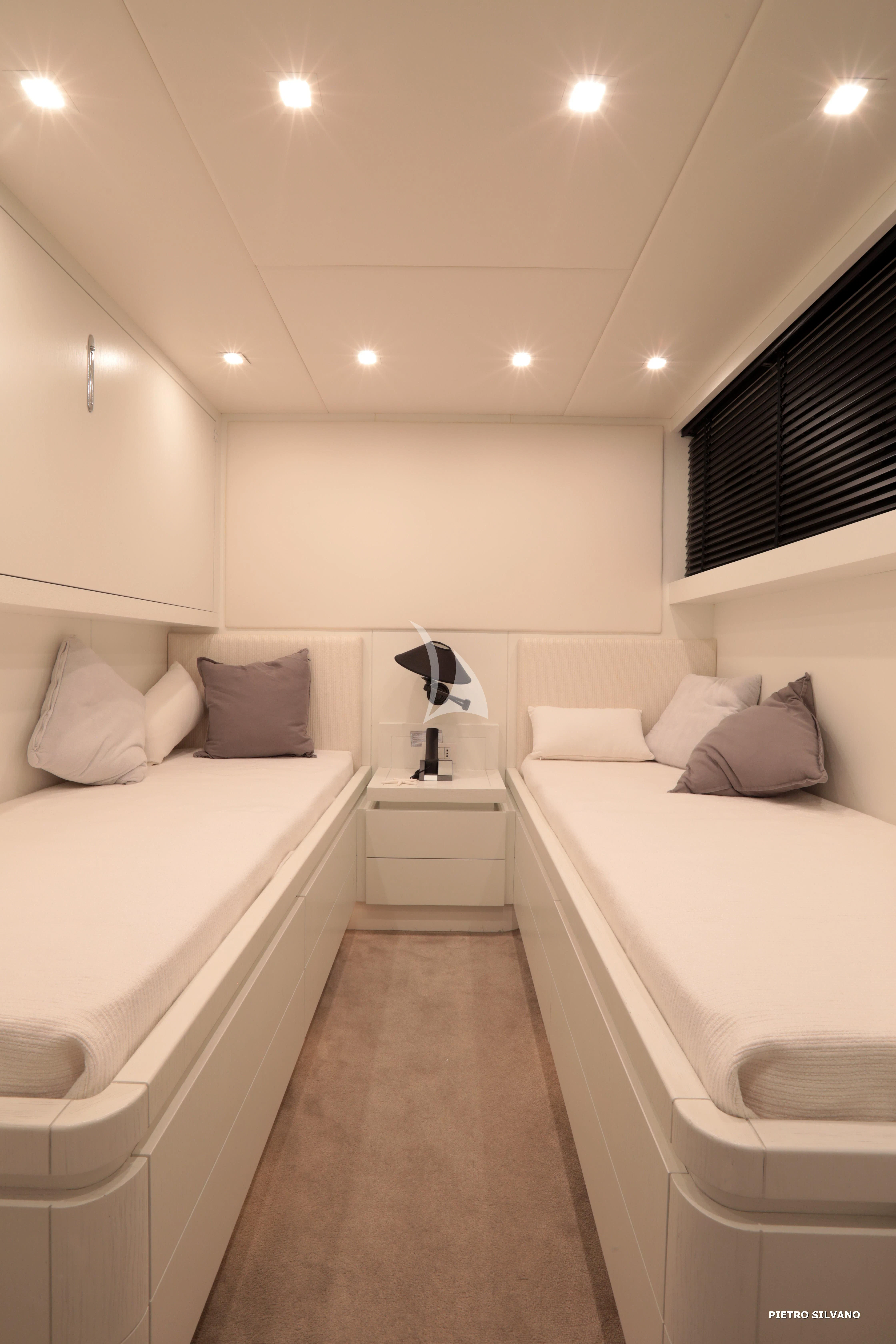 a room with a couple of white beds and a large mirror aboard NIKCA Yacht for Sale
