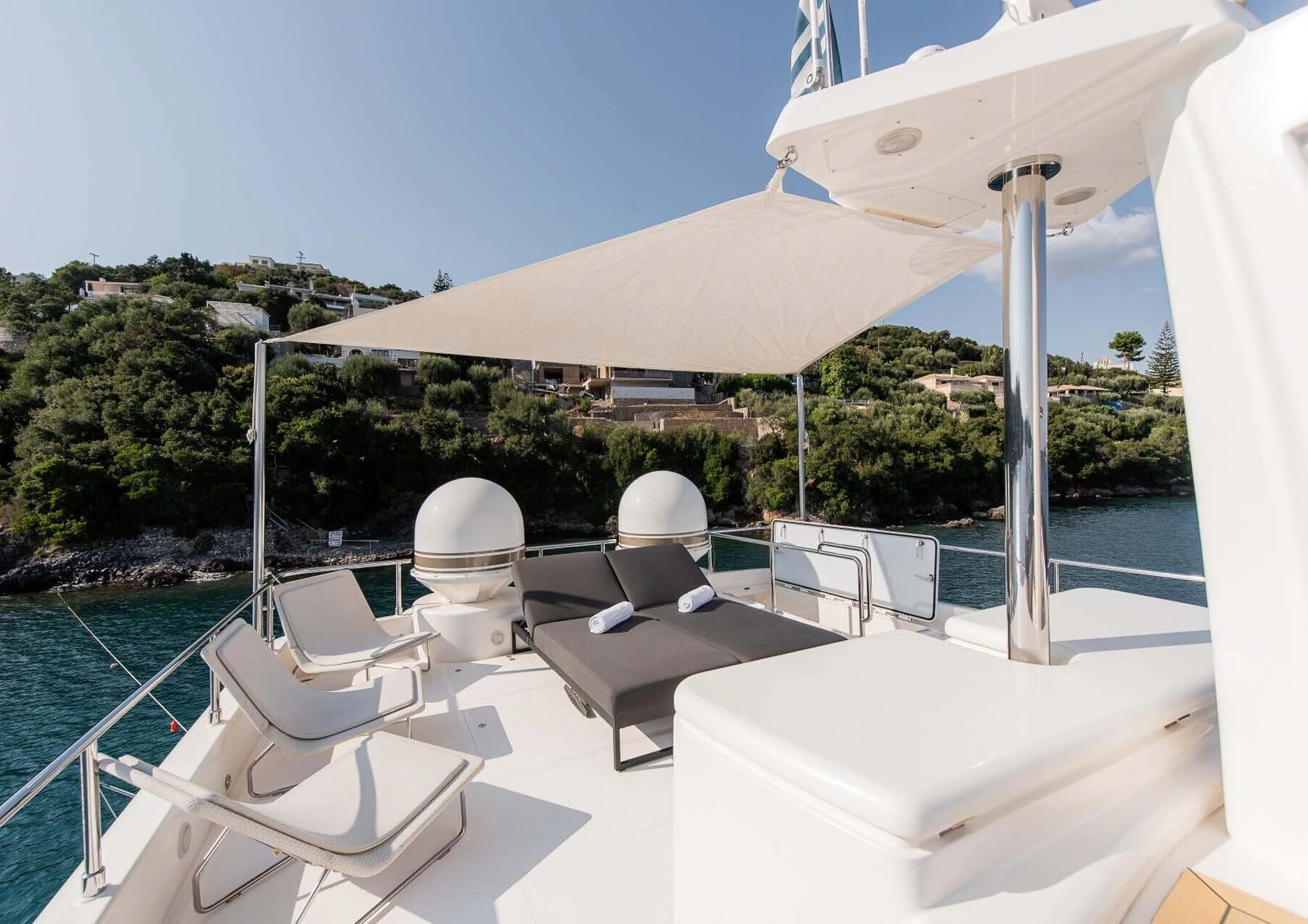 a lounge area with chairs and a large umbrella on a sunny day aboard DALOLI Yacht for Charter