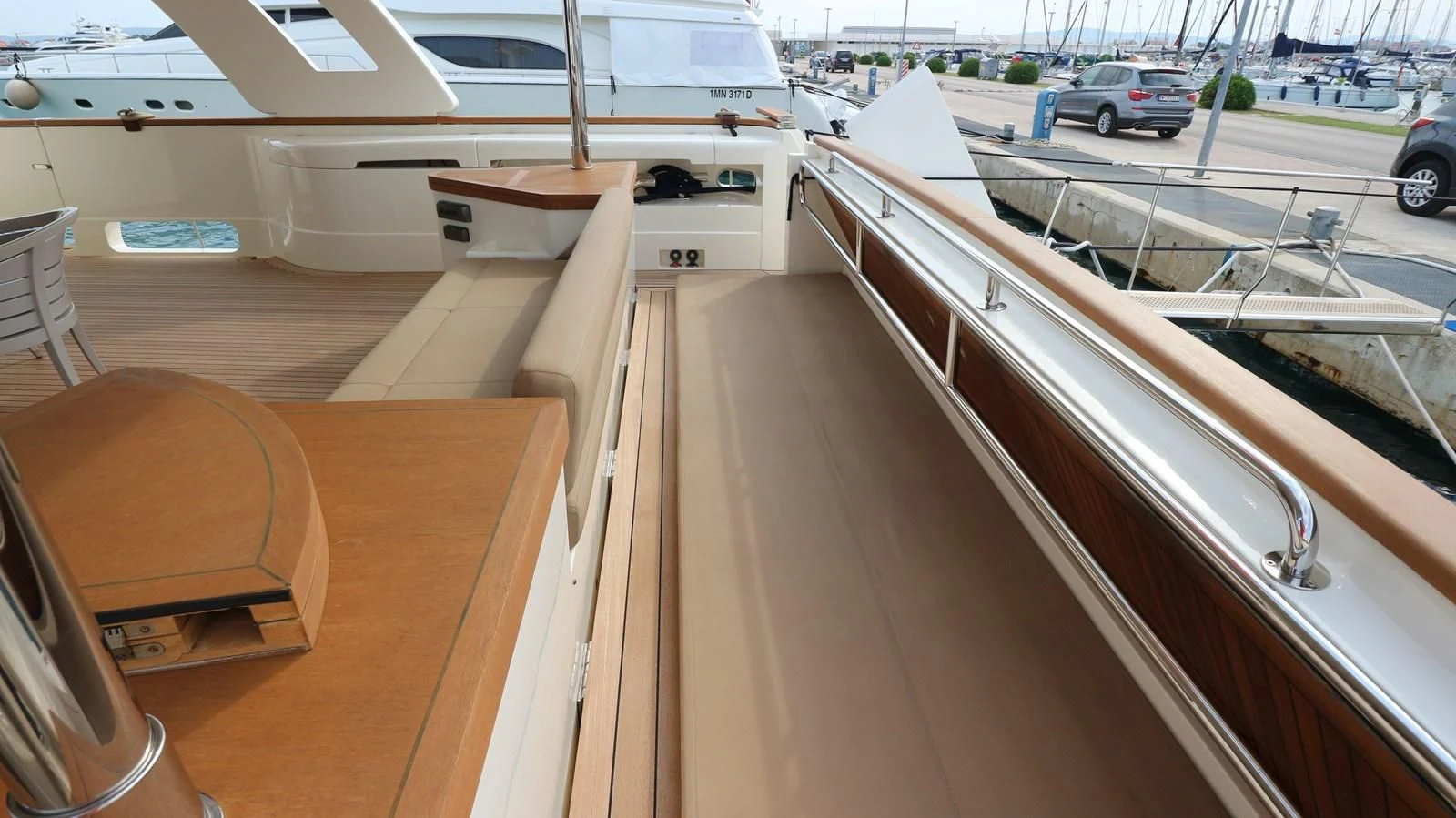 a wooden deck with a car parked in the background aboard DALOLI Yacht for Charter