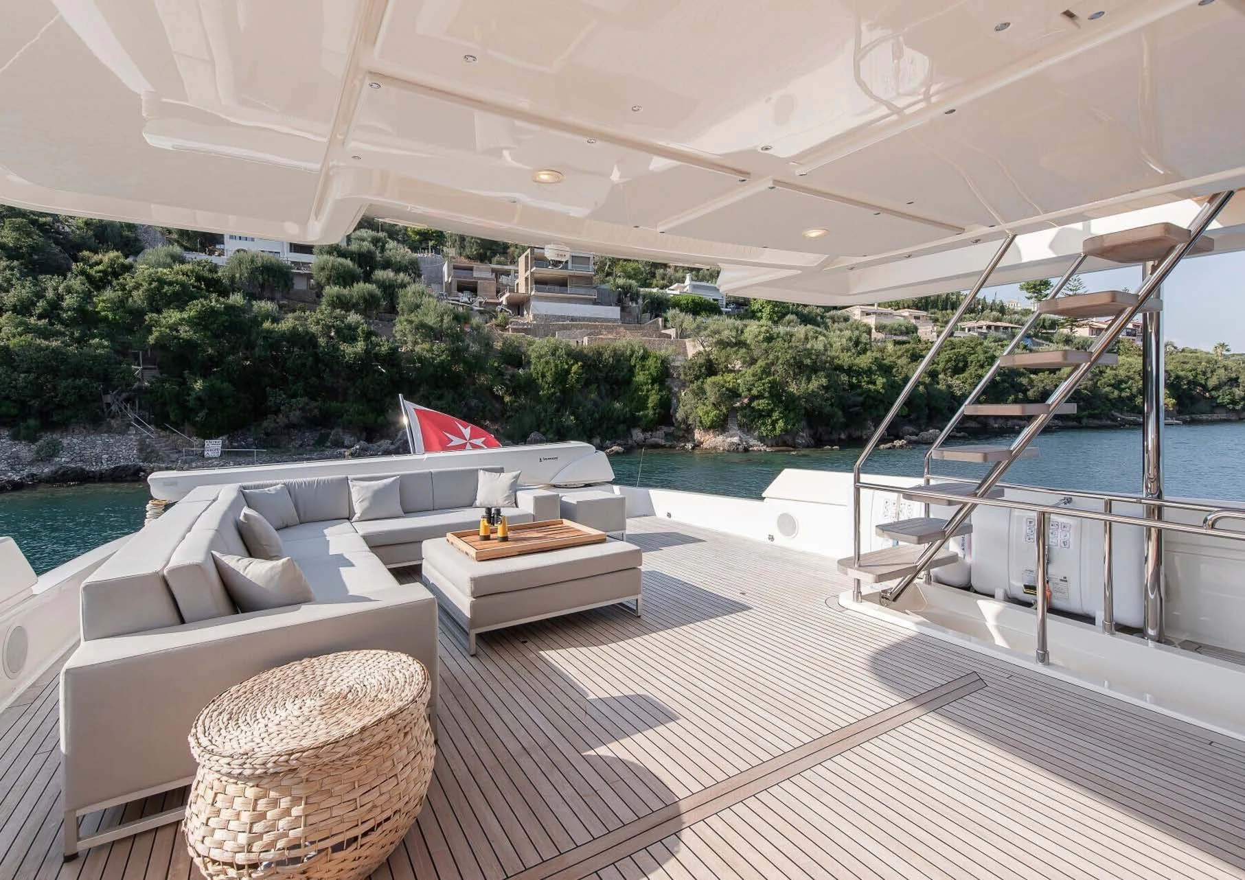 a large lounge area with a large pool and a deck with a view of trees and a city aboard DALOLI Yacht for Charter