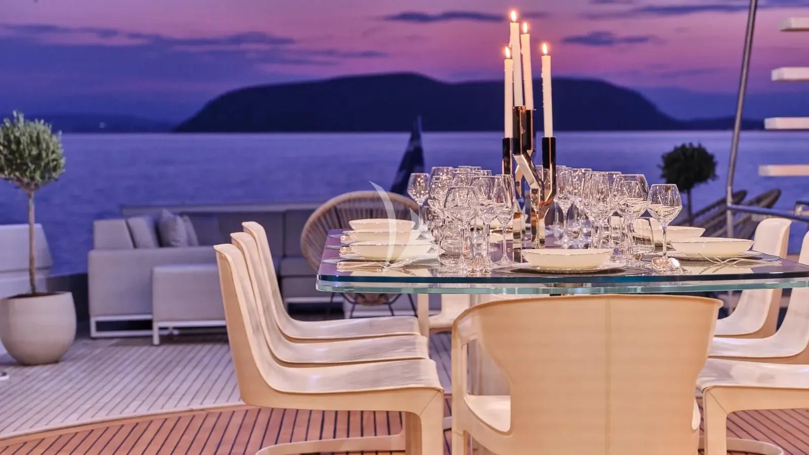 a table set with candles and a view of the ocean aboard DALOLI Yacht for Charter