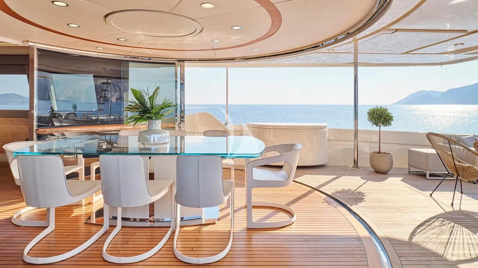 a large open area with a table and chairs and plants aboard DALOLI Yacht for Charter