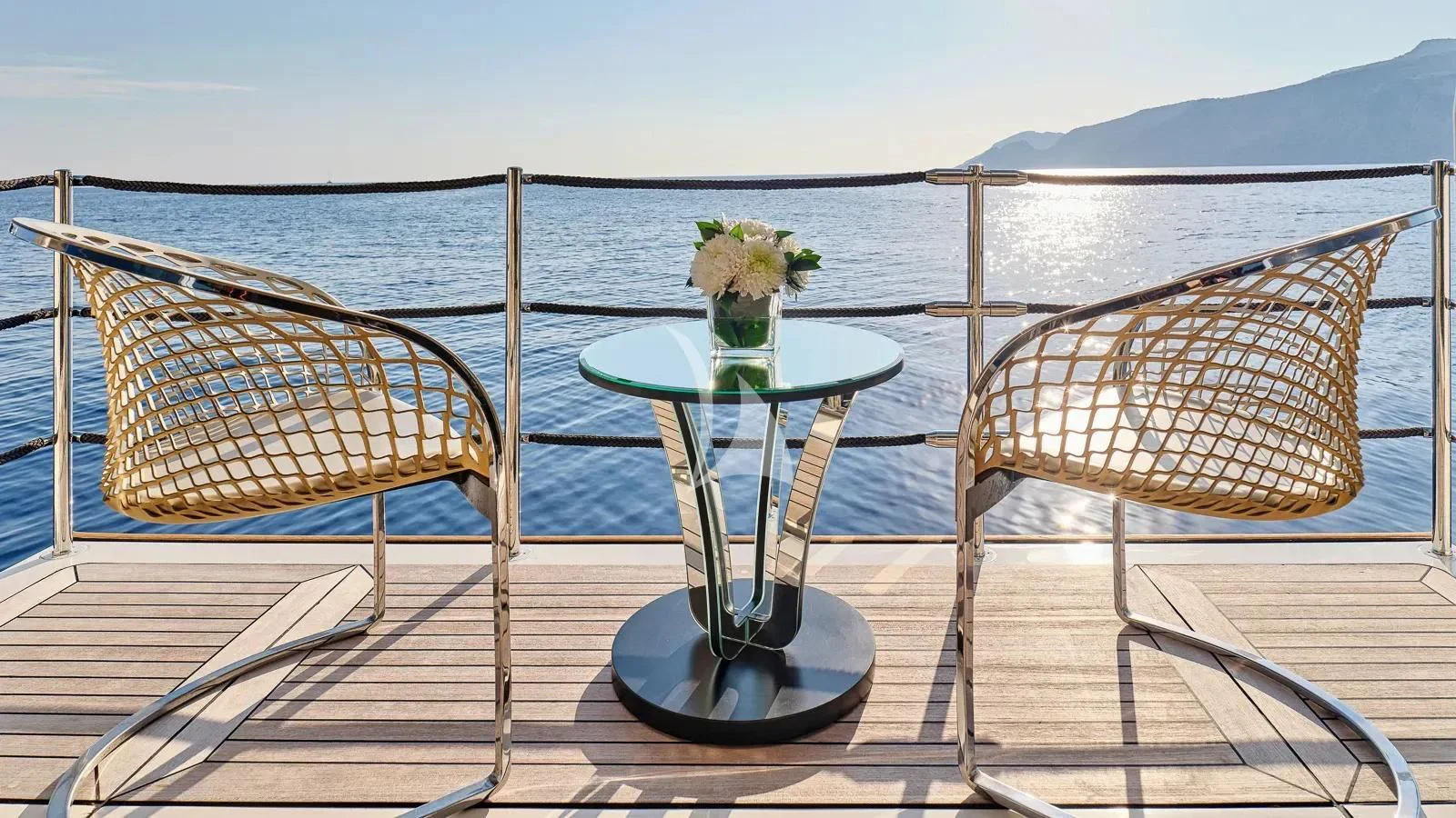 a table and chairs on a deck overlooking a body of water aboard DALOLI Yacht for Charter