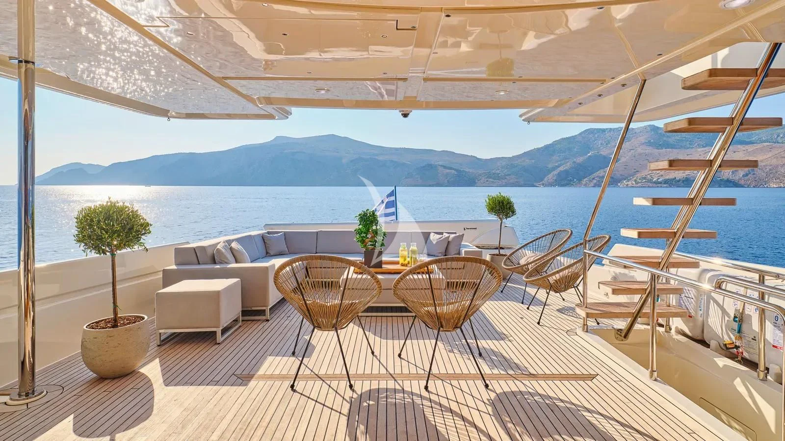 a table and chairs on a balcony overlooking a body of water aboard DALOLI Yacht for Charter
