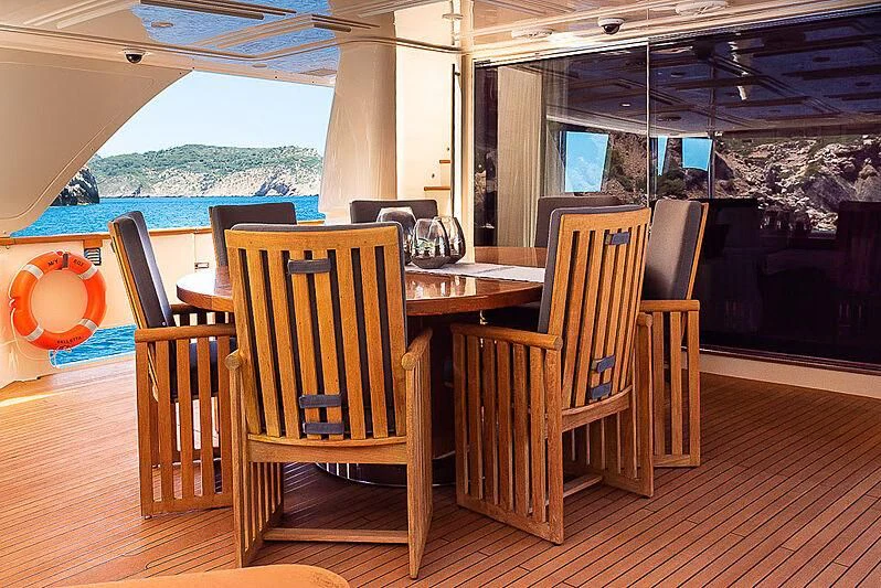 a wood deck with chairs and tables aboard BLUE LINE Yacht for Sale