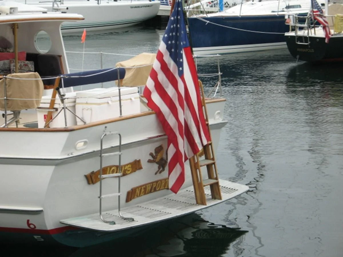 a boat with a flag on it aboard LION'S WHELP Yacht for Sale