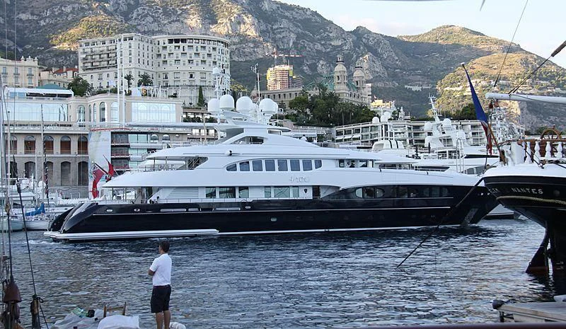 a person standing next to a large boat in a harbor aboard 4YOU Yacht for Sale